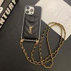 an iphone case with a chain attached to it sitting on top of a black table