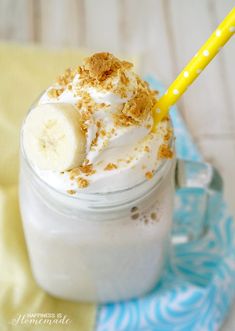 a banana and whipped cream dessert in a mason jar with a yellow straw on top