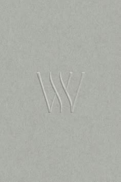 the letters w and v are made out of white paper on a gray background,