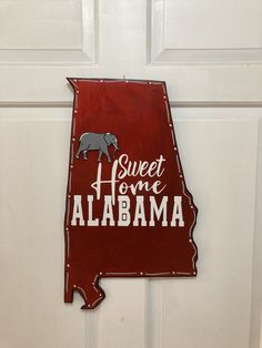 a metal sign that says sweet home to the state of alabama with an elephant on it