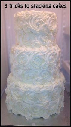 a three tiered cake with white frosting roses on it and the words, 3 tricks to stacking cakes