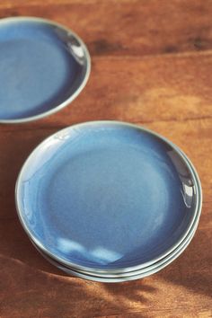 two blue plates sitting on top of a wooden table