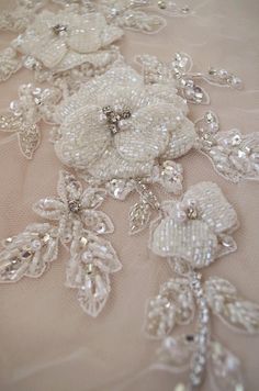 an image of wedding dress with flowers and pearls on the laces that are beaded