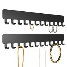 two black wall mounted jewelry racks with chains hanging from the top and one on the bottom