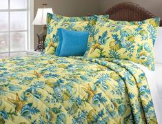 a bed with yellow and blue comforters in a bedroom