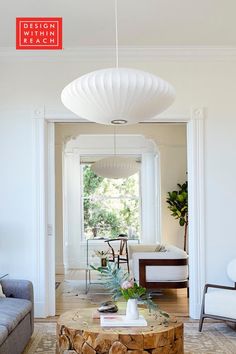 a living room filled with furniture and a large white light hanging over the top of it