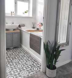 a bathroom with a sink, toilet and bathtub next to a potted plant