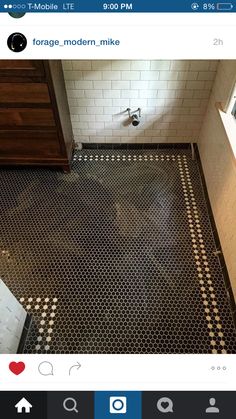 a bathroom with black and white floor tiles