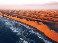 an aerial view of the ocean and sand dunes