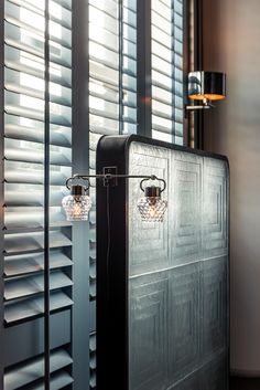 a black suitcase sitting in front of a window with shutters on it's sides