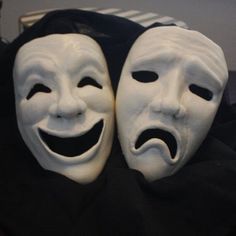 two white masks with faces painted on them