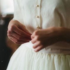 a black and white photo of a woman's hands on her waist, wearing a dress