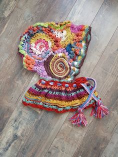 a multicolored crocheted hat laying on the floor