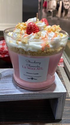 a pink bowl filled with whipped cream and strawberries