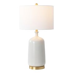 a white lamp with a gold base and a white shade on the top of it