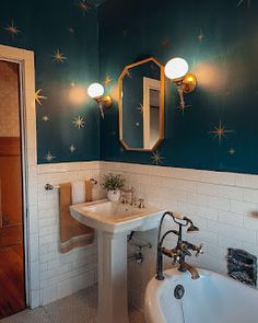 a bath room with a sink and a bath tub under a mirror next to a door