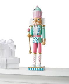 a nutcracker figurine sitting on top of a mantle next to a gift box