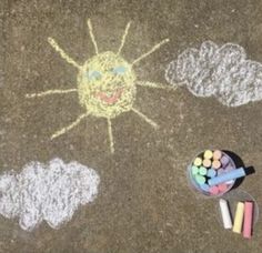 a child's drawing on the ground with chalk and crayons