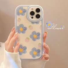 a woman holding an iphone case with flowers on it