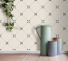 three vases are sitting on the floor in front of a wall with geometric tiles