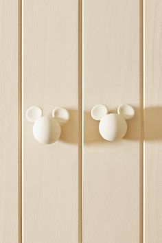 two white mickey mouse heads mounted to the side of a wall