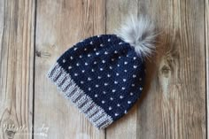 a blue and white knitted hat with a pom - pom on top