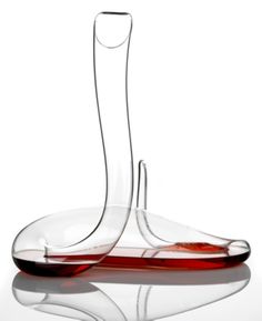 a wine decanter sitting on top of a table with red liquid in it