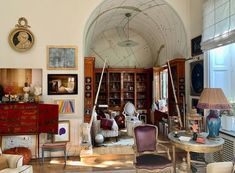 a living room filled with furniture and lots of bookshelves on top of it