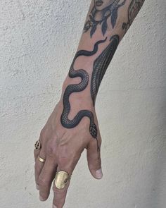 a hand with a snake tattoo on it