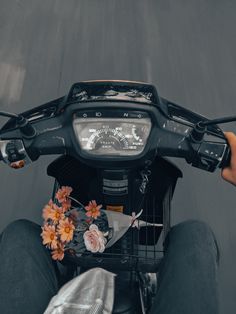 a person riding on the back of a motorcycle with flowers in front of them and a speedometer