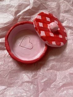 a red and white box with a heart on it sitting on a piece of paper