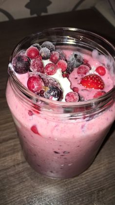 a glass jar filled with fruit on top of a wooden table