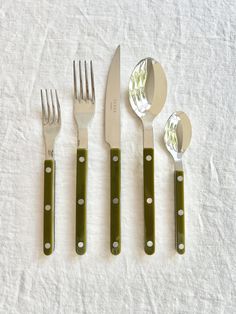 four forks, two spoons and one knife on a white cloth