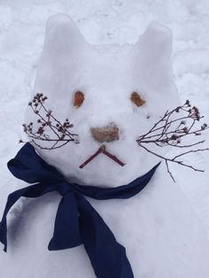 a snowman made to look like a cat with branches on it's head