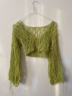 a green crop top hanging on a white wall