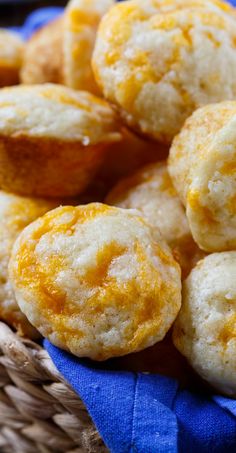 a basket filled with mini cheese muffins on top of a blue cloth