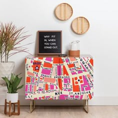 an orange and pink patterned cabinet next to a potted plant