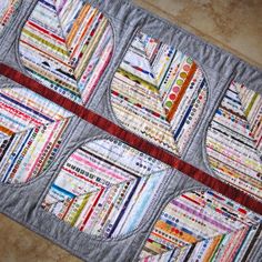 a quilted table runner with circles and strips on the edges, in various colors