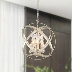 a chandelier hanging from the ceiling in a room with white walls and curtains