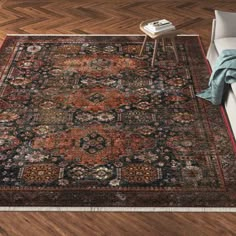 a large rug with an ornate design on the floor in front of a white couch