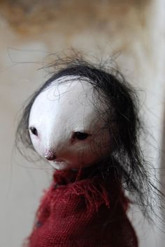 a white doll with black hair on it's head