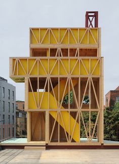 a yellow structure sitting on top of a wooden platform