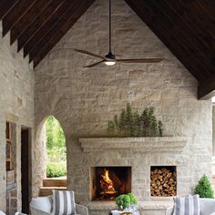 a living room with stone fireplace and chairs