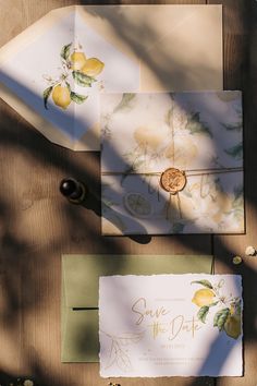 the wedding stationery has lemons painted on it and is next to an envelope that says save the date