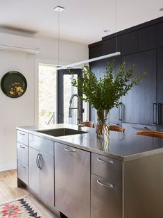 a modern kitchen with stainless steel appliances and black cabinetry is pictured in this image