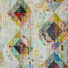 a close up of a quilt made with many different colors and designs on it's surface