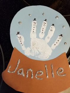 a paper plate with a hand and snowmen on it that says janelle written in silver glitters