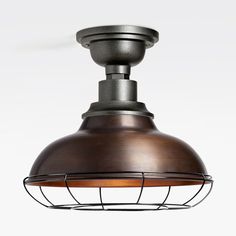 an industrial style light fixture with a metal cage on the bottom and a wooden shade