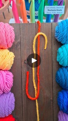 several skeins of yarn are arranged on a wooden surface next to crochet hooks