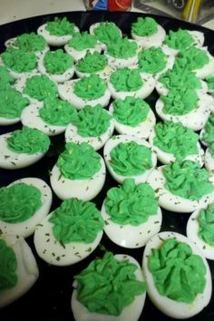 green frosted cupcakes sitting on top of a black plate